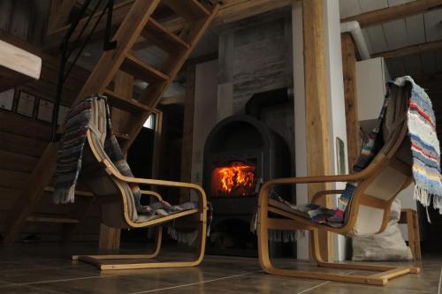 two chairs in front of a fire oven at Mednieki Kalvene in Krusāti