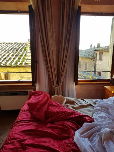 a bedroom with a bed and a window with a view at B&B Palazzo Al Torrione in San Gimignano