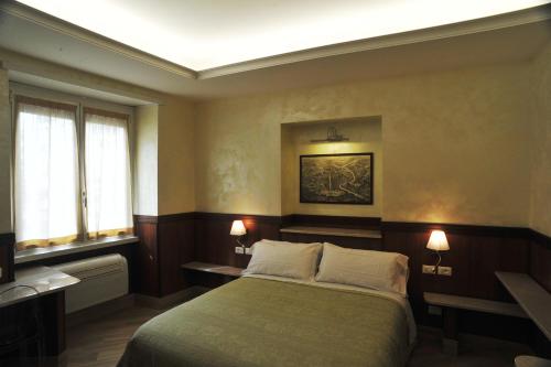 a bedroom with a bed and two windows at Residenza Matteucci in Rome