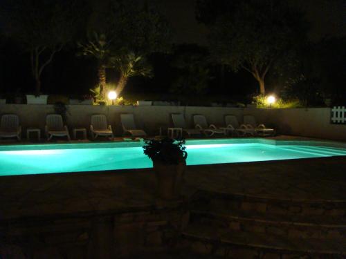 a swimming pool at night with chairs and lights at Villa Bruyere in Antibes