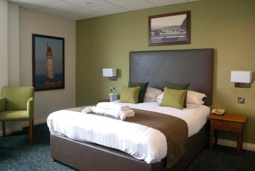 a bedroom with a large bed and a chair at Sandbanks Hotel in Poole