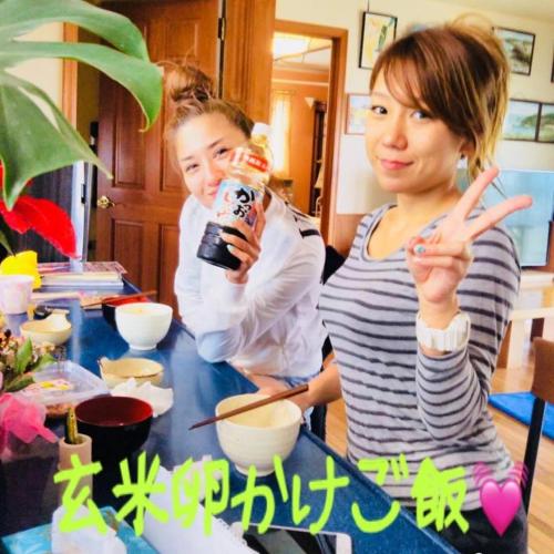 two girls standing at a table with a drink at 宮古島サイクリストの宿 in Miyako Island