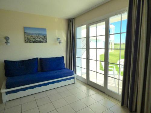 - un canapé bleu dans une chambre avec une grande fenêtre dans l'établissement Appartement T2 Residence Le Club, à Talmont-Saint-Hilaire