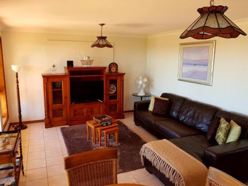 a living room with a couch and a tv at Jervis Bay Blue - Vincentia in Vincentia