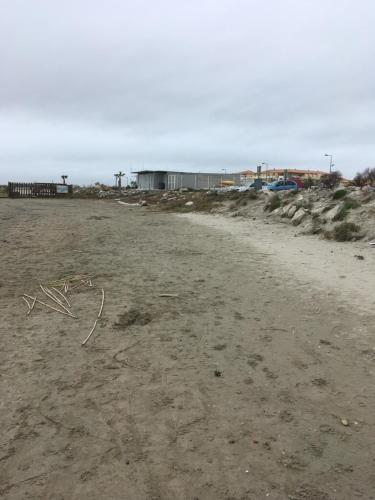 a sandy beach with a building in the background at le grand large in Sète