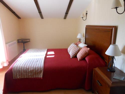 a bedroom with a large red bed with two pillows at La Aragonesa in Marmolejo