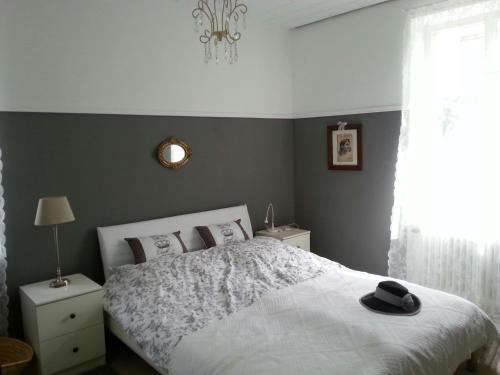 a bedroom with a bed with a black hat on it at Das Rosenhaus in Lieser