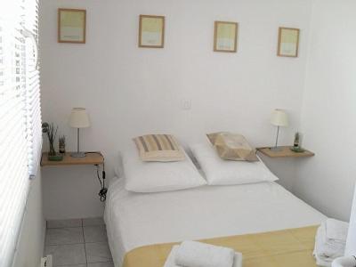 - une chambre blanche avec un lit blanc et deux lampes dans l'établissement Apartment Massoury, à Cannes