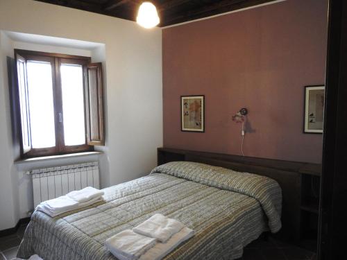 a bedroom with a bed with towels on it at Locanda Il Falco Nero in Fumone