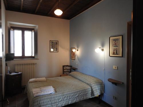 Habitación pequeña con cama y ventana en Locanda Il Falco Nero, en Fumone