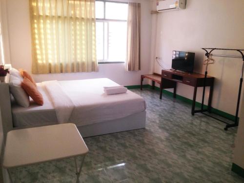 a bedroom with a bed and a desk and a television at is boutique huahin hotel in Hua Hin
