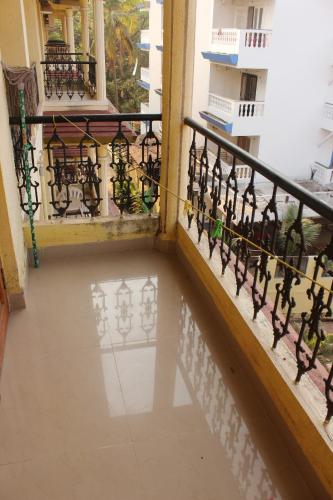 a balcony of a building with a reflection in the water at Cozy Candolim Apartment fully furnished for five adults in Candolim