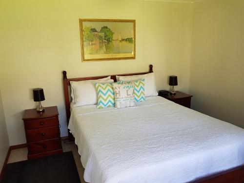 文森提亞的住宿－文森提亞藍色傑維斯灣公寓，一间卧室配有白色床和2个床头柜