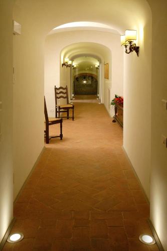 a hallway with two chairs in a building at Villa Barberino in Meleto
