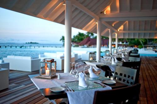 a restaurant with a table with a view of the ocean at Diamonds Thudufushi Maldives Resort & Spa in Thundufushi