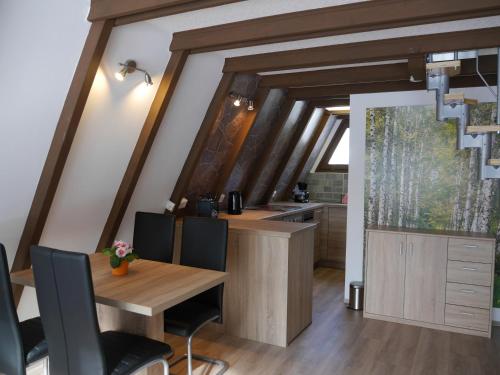 uma cozinha com uma mesa de madeira e uma sala de jantar em Ferienhaus im Nordschwarzwald - Nurdachhaus in Waldrandlage em Schellbronn