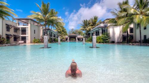 uma mulher na água num resort em Luxury Apartments at Temple Resort and Spa Port Douglas em Port Douglas