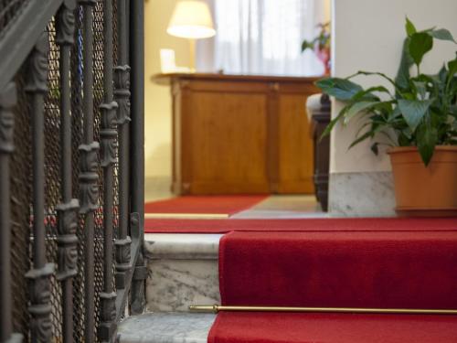 a red and white fire hydrant next to a stair case at Hotel Manganelli Palace in Catania