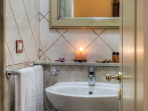 a bathroom with a sink and a candle on a shelf at Hotel Manganelli Palace in Catania