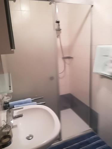 a bathroom with a white sink and a shower at Ferienwohnung Bergblick in Schmirn