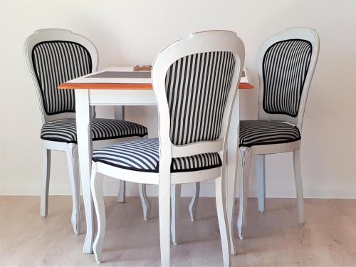 a dining room table with two chairs and a white table and chairsskirts at Appartement-Villa Steinfurth in Binz