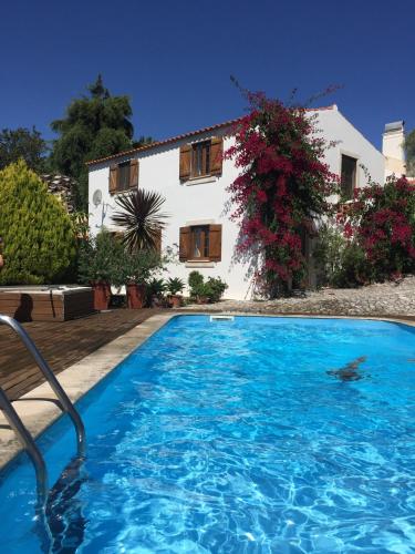 a swimming pool in front of a house at Casal dos Melros in Cruzes