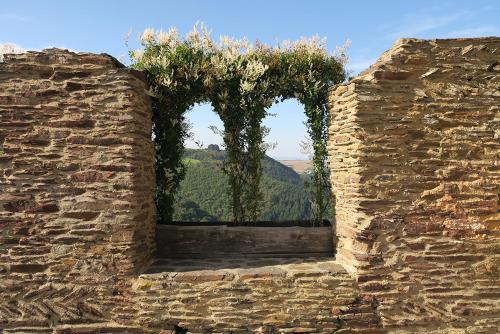 a stone wall with two windows with trees in them at Pension "Haus am Walde" Brodenbach, Mosel in Brodenbach