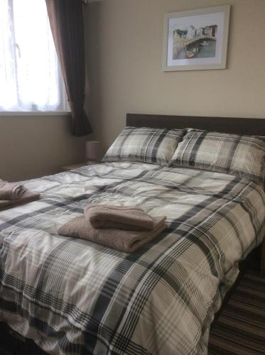 een slaapkamer met een bed met twee handdoeken erop bij Dawlish Warren Apartments in Dawlish