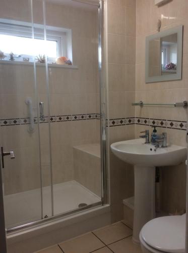 y baño con ducha y lavamanos. en Dawlish Warren Apartments, en Dawlish