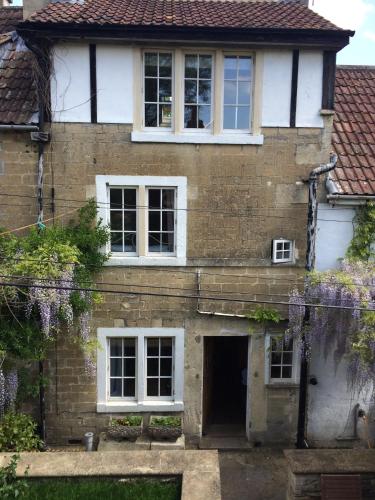 an old brick house with white windows and a door at Bradford on Avon holiday cottage 4 bedroom near Bath in Bradford on Avon