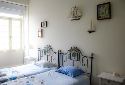 um quarto com 2 camas e almofadas azuis em Alameda Guest House em Espinho