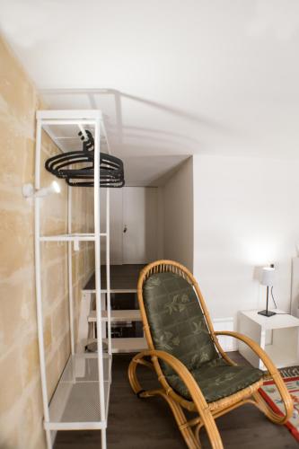 a room with a green chair and a shelf at Sulla roccia dei Sassi in Matera