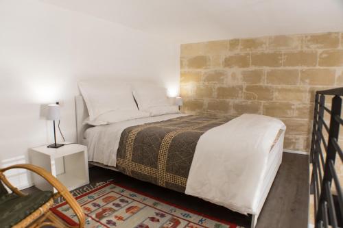 a bedroom with a bed and a brick wall at Sulla roccia dei Sassi in Matera