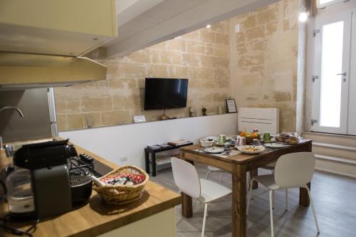 una cucina con tavolo e sedie in una stanza di Sulla roccia dei Sassi a Matera