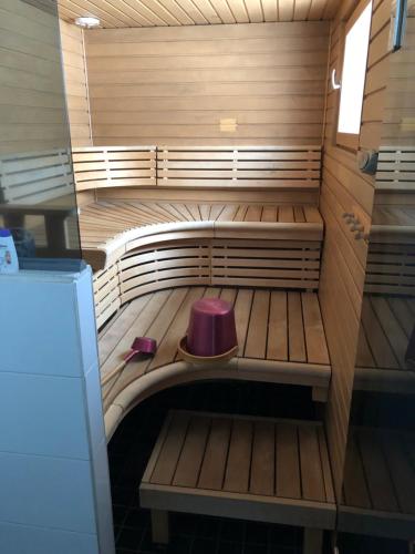 een kleine sauna met een paarse kruk erin bij Harjuniemi in Kangosjärvi