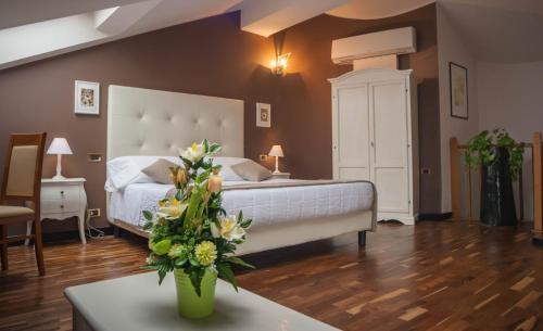 a bedroom with a bed and a table with a vase of flowers at Hotel Asnigo in Cernobbio