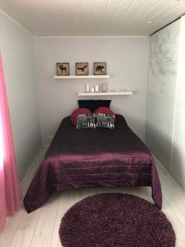 ein Schlafzimmer mit einem lila Bett mit Kissen darauf in der Unterkunft Harjuniemi in Kangosjärvi
