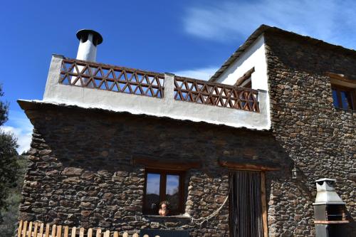 a stone house with a balcony on top of it at Dreams Alpujarra in Pampaneira