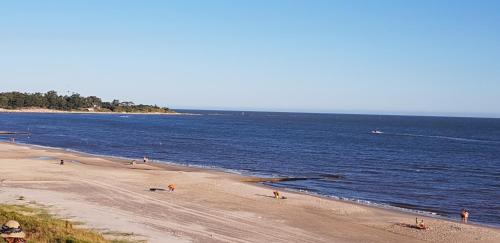 a group of people on a beach near the water at La Quimera a pasos de la playa in Atlántida