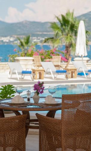 a table and chairs next to a swimming pool at Torbahan Hotel in Torba