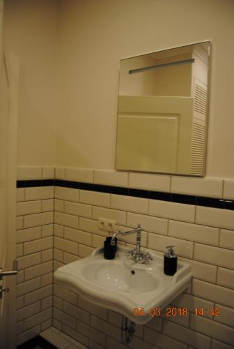 W łazience znajduje się umywalka i lustro. w obiekcie Schöne Ferienwohnung zentral gelegen w Kilonii