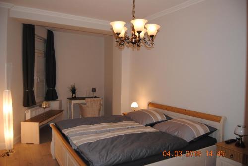 a bedroom with two beds and a chandelier at Schöne Ferienwohnung zentral gelegen in Kiel