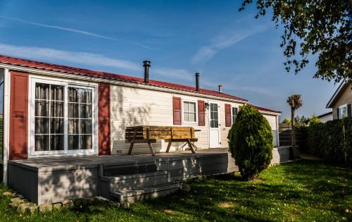 a house with a bench on the front porch at Chaletparc Krabbenkreek Zeeland - Chalet 6 in Sint Annaland