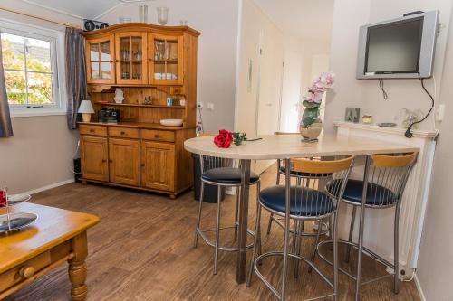 シント・アナラントにあるChaletparc Krabbenkreek Zeeland - Chalet 6のキッチン(テーブル、椅子、テレビ付)