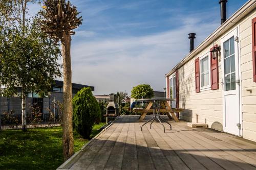 a picnic table on a patio next to a building at Chaletparc Krabbenkreek Zeeland - Chalet 6 in Sint Annaland
