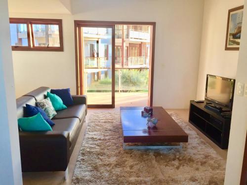 ein Wohnzimmer mit einer Couch und einem Couchtisch in der Unterkunft Taiba Beach Resort Casa com piscina in Taíba