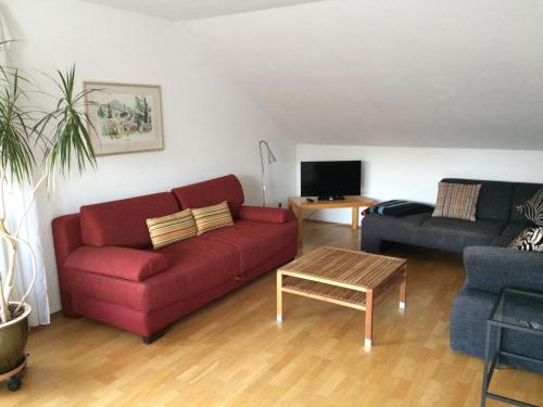 a living room with a red couch and a table at Konstanz-Wallhausen in Konstanz