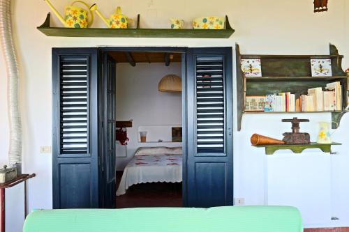 een kamer met een blauwe deur met een bed erin bij Villa Miele in Lipari