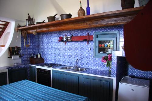 een keuken met een wastafel en een blauwe tegelmuur bij Villa Miele in Lipari