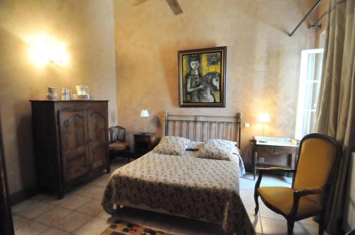a bedroom with a bed and a desk and a chair at Domaine du Grand Malherbes in Aimargues